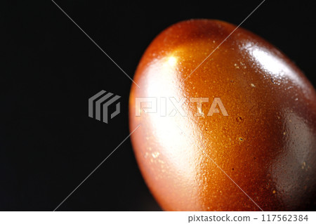 Smoked eggs photographed against a black background Smoked eggs photographed against a black background 117562384