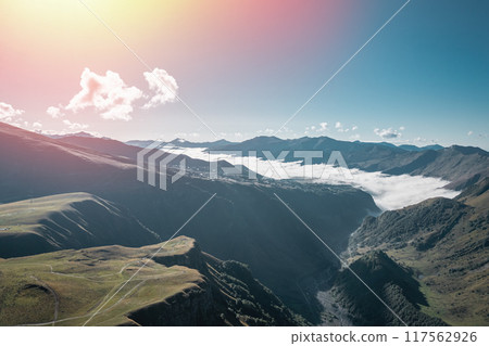 Experience the stunning mountain view with clouds and sunlight illuminating the valley below Experience the stunning mountain view with clouds and sunlight illuminating the valley below 117562926