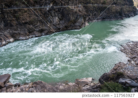 The landscape of Tiger Leaping Gorge in Yunnan province of China. Scenic spot where a tiger is said to have leaped across the river, thus giving the gorge its name. 117563927