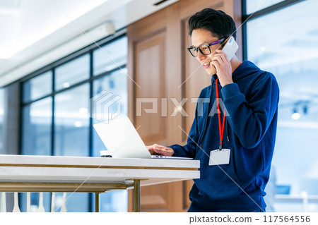 A man touching a smartphone in the office Photo cooperation: WEEK Shibadaimon (Sun Frontier Fudousan) 117564556