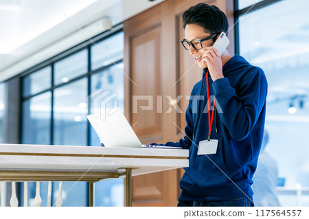 A man touching a smartphone in the office Photo cooperation: WEEK Shibadaimon (Sun Frontier Fudousan) 117564557