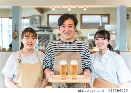 Izakaya, restaurant, and cafe staff (three people) holding draft beer 117564673