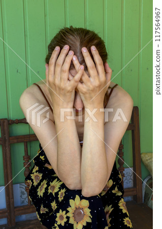 Woman covered her face with her palms, expressing weariness and despair. An unrecognizable person. Close-up 117564967