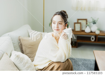 Woman drinking hot coffee in her room Woman drinking hot coffee in her room 117565103