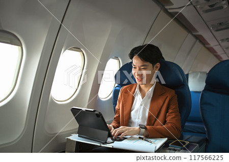Successful businessman in elegant suit working with digital in aircraft during business travel 117566225