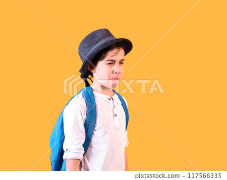 Sad Child with Backpack on Orange Background Sad Child with Backpack on Orange Background 117566335