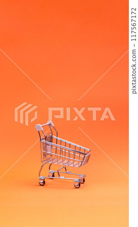 Empty Shopping trolley on orange background. Shopping cart, supermarket trolley concept. Vertical banner minimal copy space Empty Shopping trolley on orange background. Shopping cart, supermarket trolley concept. Vertical banner minimal copy space 117567172