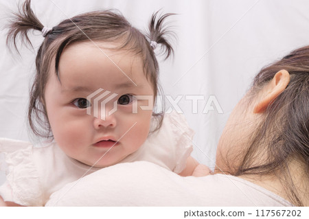 [Baby with twin tails being held by grandmother] 117567202