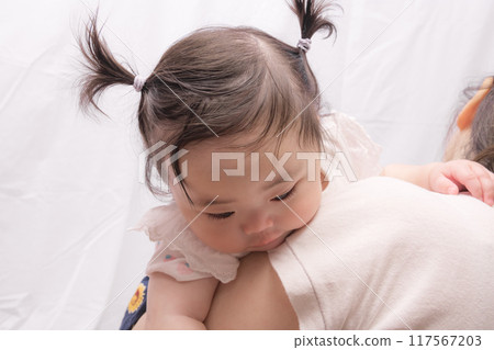[Baby with twin tails being held by grandmother] 117567203
