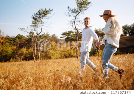 Young couple having fun walking and hugging n the park. Autumn weather. Relaxation, youth. 117567374