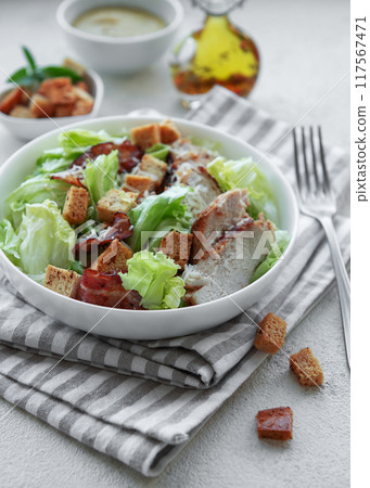 A bowl  of  Caesar salad 117567471