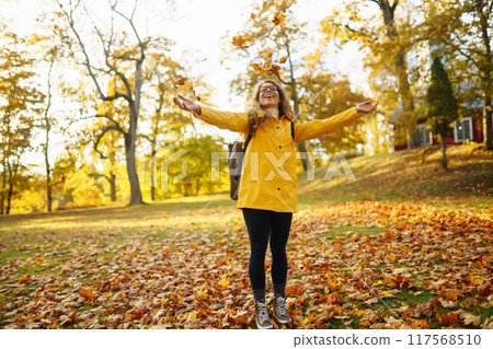 Hiking in autumn forest. Tourist walks through autumn park in sunny weather. Adventure concept. 117568510