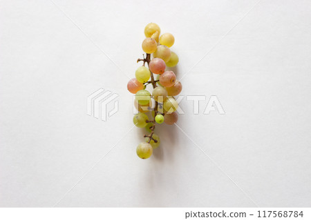 A bunch of mismatched grapes placed in the center of a landscape white sheet of paper 117568784