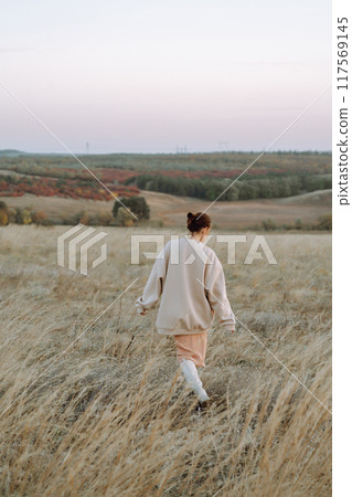 Beautiful woman walk in the field sunny day 117569145