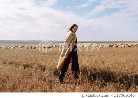 Young woman in stylish clothes posing in autumn field. Nature, fashion, lifestyle. Travel. Young woman in stylish clothes posing in autumn field. Nature, fashion, lifestyle. Travel. 117569146