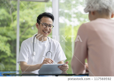 Male doctor examining with a smile 117569592