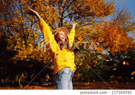 Young woman in a yellow sweater and jeans resting in nature. Fashion, style concept. People, lifestyle. 117569595