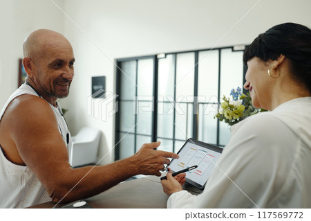 Client Discussing Sport Program With Administrator 117569772