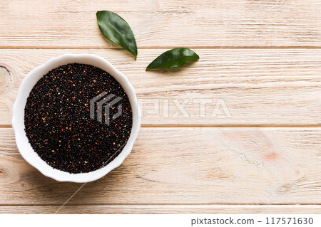 quinoa seeds in bowl on colored background. Healthy kinwa in small bowl. Healthy superfood quinoa seeds in bowl on colored background. Healthy kinwa in small bowl. Healthy superfood 117571630