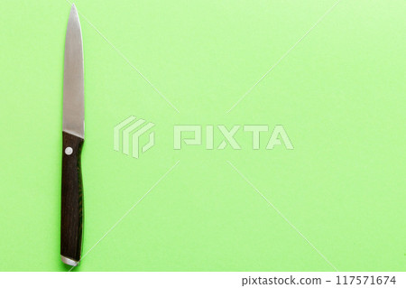 A simple kitchen knife with wooden handle, top view isolated on green background A simple kitchen knife with wooden handle, top view isolated on green background 117571674