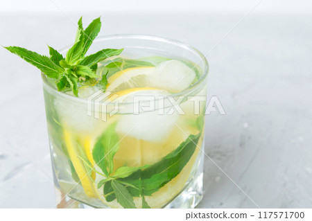 Mojito summer refreshing cocktail with ice and mint. mojito cocktail with lime, lemon and mint in a tall glass with a stick Mojito summer refreshing cocktail with ice and mint. mojito cocktail with lime, lemon and mint in a tall glass with a stick 117571700