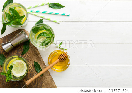 Caipirinha, Mojito cocktail, vodka or soda drink with lime, mint and straw on table background. Refreshing beverage with mint and lime in glass top view flat lay 117571704