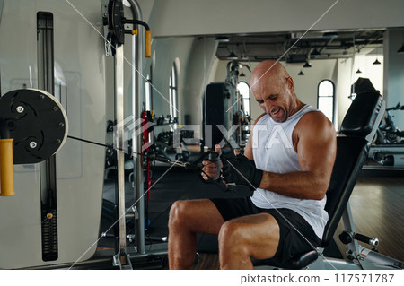 Man Pumping His Muscles On Sport Equipment 117571787