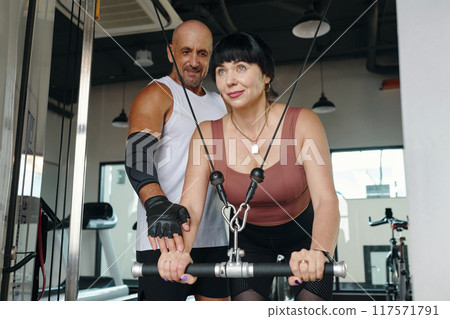 Woman Training With Personal Trainer In Gym Woman Training With Personal Trainer In Gym 117571791