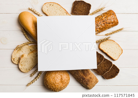 Minimalist paper blank mockup on background of Types of homemade bread. Different kinds of fresh bread as background, top view with space for your text or design 117571845