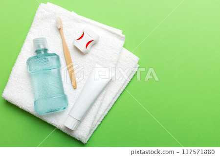 Mouthwash and other oral hygiene products on colored table top view with copy space. Flat lay. Dental hygiene. Oral care products and space for text on light background. concept 117571880