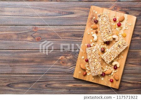 Various granola bars on table background. Cereal granola bars. Superfood breakfast bars with oats, nuts and berries, close up. Superfood concept 117571922