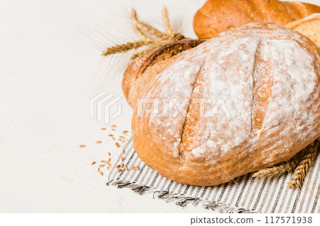 Homemade natural breads. Different kinds of fresh bread as background, perspective view with copy space Homemade natural breads. Different kinds of fresh bread as background, perspective view with copy space 117571938