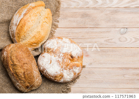 Assortment of freshly baked bread with napkin on rustic table top view. Healthy unleavened bread. French bread 117571963