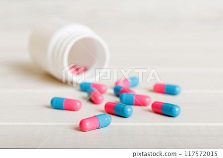 plastic medicine bottle with capsules of pills on colored background. Online pharmacy. Painkiller medicine and antibiotic drug resistance concept. Pharmaceutical industry 117572015