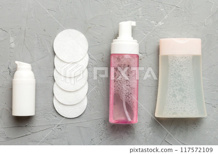 Micellar cleansing water and discs to remove cosmetics and cleanse the skin on colored background. Copy space top view Micellar cleansing water and discs to remove cosmetics and cleanse the skin on colored background. Copy space top view 117572109