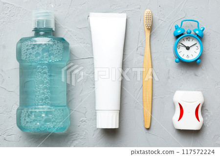 Mouthwash and other oral hygiene products on colored table top view with copy space. Flat lay. Dental hygiene. Oral care products and space for text on light background. concept 117572224