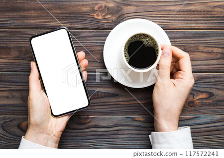 Top view of woman hands holding smart phone with blank copy space screen for your text message or information content. woman hand using phone white screen on top view Top view of woman hands holding smart phone with blank copy space screen for your text message or information content. woman hand using phone white screen on top view 117572241