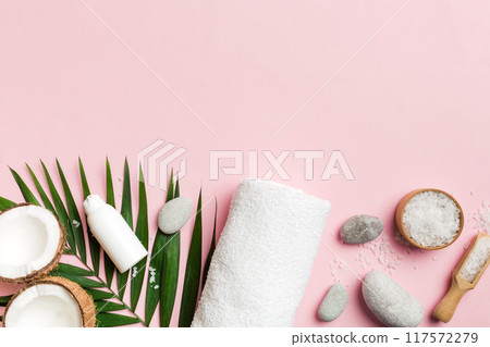 Coconut with jars of coconut oil and cosmetic cream on colored background. Top view. Free space for your text. Natural spa coconut cosmetics and organic treatment concept Coconut Spa composition 117572279