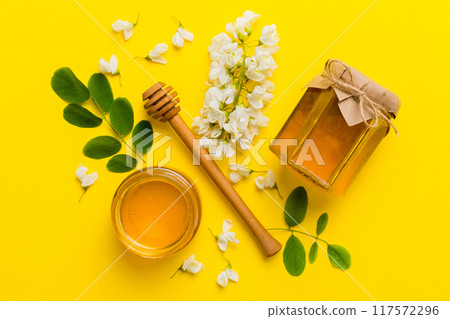 honey jar with acacia flowers and leaves. fresh honey top view flat lay honey jar with acacia flowers and leaves. fresh honey top view flat lay 117572296