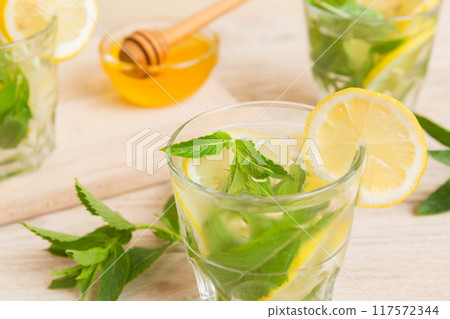 Mojito cocktail. Refreshing mojito cocktail with lime, lemon and mint in a tall glass with a stick 117572344