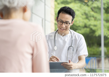 Male doctor examining senior women Male doctor examining senior women 117572873