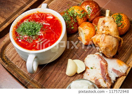 Borsch with pampushkas, chicken drumstick, lard and garlic Borsch with pampushkas, chicken drumstick, lard and garlic 117572948