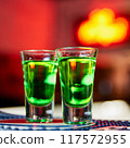 Green Alcoholic drink in shots on the bar counter 117572955