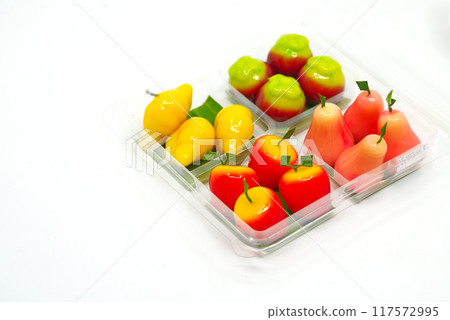 Cute art food, Thai snacks in the shape of fruits in four panels plastic package on white background. It is called Look Choop or Luk Chab in Thai language, made from mung beans, sugar and gelatin. Cute art food, Thai snacks in the shape of fruits in four panels plastic package on white background. It is called Look Choop or Luk Chab in Thai language, made from mung beans, sugar and gelatin. 117572995