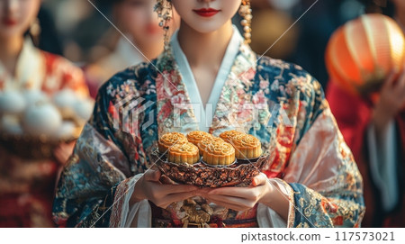 A young woman wearing traditional Chinese clothing Hanfu, holding mooncakes. Mid-Autumn festival A young woman wearing traditional Chinese clothing Hanfu, holding mooncakes. Mid-Autumn festival 117573021