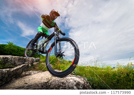 Cyclist riding a mountain bike downhill style. Extreme sports on a bicycle outdoors Cyclist riding a mountain bike downhill style. Extreme sports on a bicycle outdoors 117573990