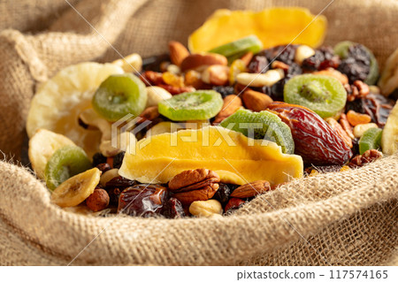 Dried tropical fruits and nuts in burlap bag. Dried tropical fruits and nuts in burlap bag. 117574165
