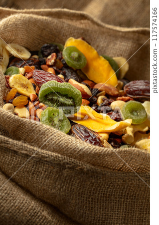 Dried tropical fruits and nuts in burlap bag. Dried tropical fruits and nuts in burlap bag. 117574166