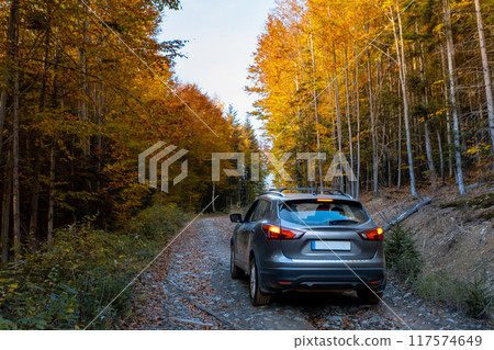 SUV on a Scenic Autumn Gravel Road SUV on a Scenic Autumn Gravel Road 117574649
