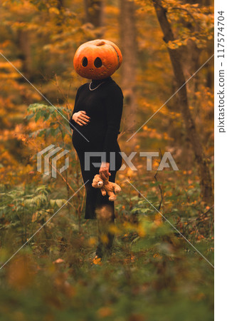 pregnant woman with pumpkin head halloween costume 117574704